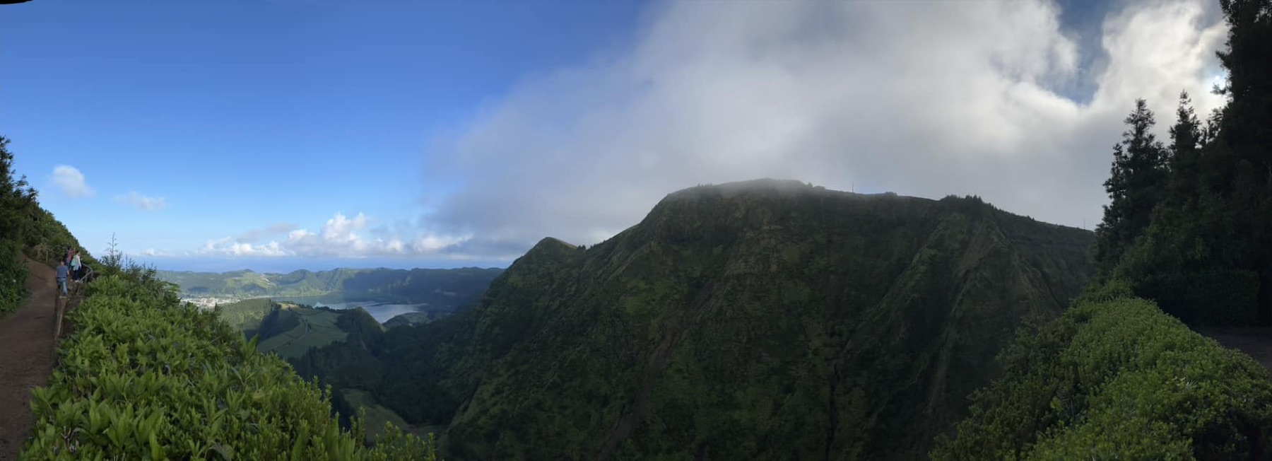 Green volcanic mountains beneath shifting clouds in the Azores